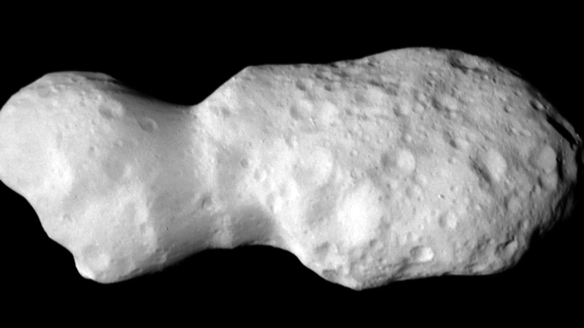 Lucy flyby finds a tumbling asteroid with traces of ancient water