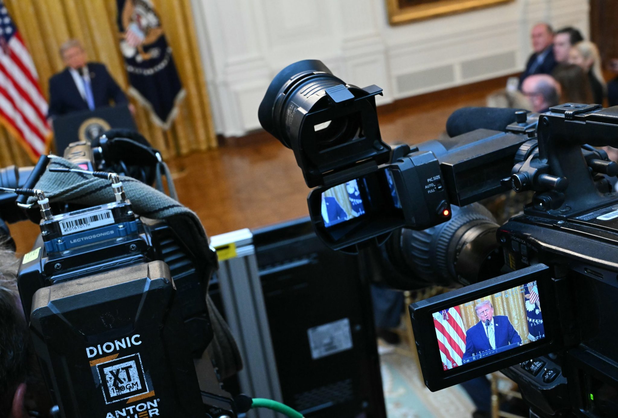 Networks split coverage of Trump address after license threats